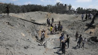 Palestinians search for bodies and survivors in a site hit by an Israeli bombardment.