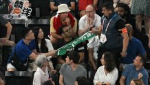 A security member removes a banner showing the name "Taiwan" from a fan in the audience