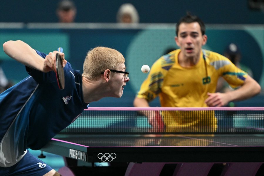 France's Felix Lebrun serves to Brazil's Hugo Calderano during their men's table tennis singles bronze medal match at the Paris 2024 Olympic Games at the South Paris Arena in Paris on August 4, 2024