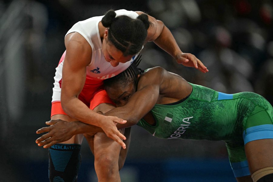 France's Koumba Larroque wrestles Nigeria's Blessing Oborududu (blue) during their women's freestyle 68kg wrestling quarter-final match at the Champ-de-Mars Arena during the Paris 2024 Olympic Games, in Paris on August 5, 2024