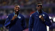 PARIS, FRANCE - AUGUST 05: Gold medalist Noah Lyles of Team United States (L) and Bronze medalist Fred Kerley of Team United States (R) celebrate on the podium during the Men's 100m medal ceremony on day ten of the Olympic Games Paris 2024 at Stade de France on August 05, 2024 in Paris, France. (Photo by Cameron Spencer/Getty Images)