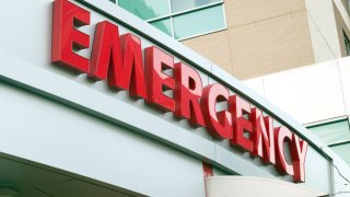 Large red EMERGENCY sign on hospital entrance. Raw original.