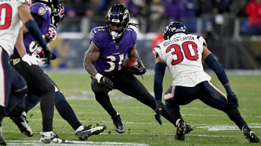 Jan 20, 2024; Baltimore, MD, USA; Baltimore Ravens running back Dalvin Cook (31) runs the ball against Houston Texans linebacker Blake Cashman (53) and safety DeAndre Houston-Carson (30) during the fourth quarter of a 2024 AFC divisional round game at M&T Bank Stadium.