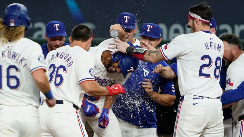 Aug 31, 2024; Arlington, Texas, USA; Texas Rangers center fielder Leody Taveras (3) is mobbed by teammates after hitting a walk-off single during the ninth inning against the Oakland Athletics at Globe Life Field. (Mandatory Credit: Raymond Carlin III-USA TODAY Sports)