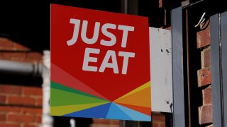 A Just Eat sign displayed at the front of a pizza takeaway shop on May 19, 2020 in Fleet, England.