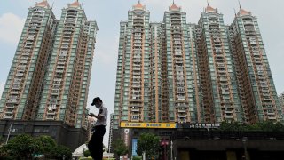 A man walks past a housing complex by Chinese property developer Evergrande in Guangzhou, China’s southern Guangdong province on September 17, 2021.