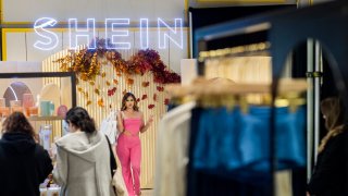 Shoppers Ashley Sanchez, center, of Fontana, poses for her friend Joscelin Flores, not pictured, who was taking photos with their bags of merchandise after being among the first group of shoppers taking the opportunity to shop on the opening day of fast fashion e-commerce giant Shein, which is hosting a brick-and-mortar pop up inside Forever 21 at the Ontario Mills Mall in Ontario Thursday, Oct. 19, 2023.