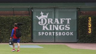 A DraftKings Sportsbook logo is posted on the right field wall of Chicago&apos;s Wrigley Field before a game between the Chicago Cubs and Philadelphia Phillies on Sept. 27, 2022. 