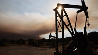 Oil pumpjacks operate as the Lake Fire burns in Los Padres National Forest with evacuation warnings in the area on July 6, 2024 near Los Olivos, California. 