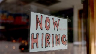 A ‘Now Hiring’ sign posted on the window of a business looking to hire workers on May 05, 2023 in Miami, Florida. 