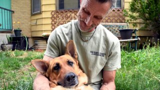 Simon Rubick, who sought help from PAWsitive Recovery while he was recovering from drug and alcohol addiction, holds his rescue dog Tonks in Aurora, Colo., on Monday, June 3, 2024.