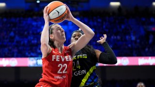 Indiana Fever guard Caitlin Clark (22) leaps to the basket for a shot as Dallas Wings’ Arike Ogunbowale (24) defends in the first half of a WNBA basketball game Sunday, Sept. 1, 2024, in Arlington, Texas. (AP Photo/Tony Gutierrez)