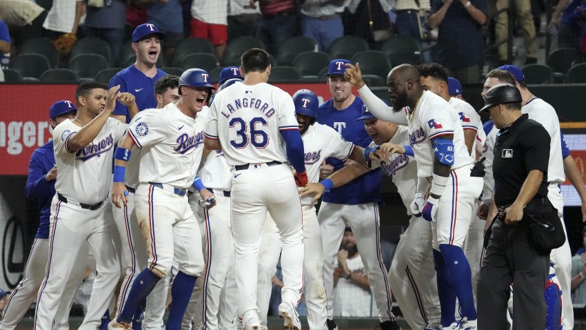 Texas Rangers’ Wyatt Langford (36) is greeted at home plate after hitting a walk-off grand slam off of New York Yankees relief pitcher Clay Holmes during the ninth inning of a baseball game Tuesday, Sept. 3, 2024, in Arlington, Texas. Leody Taveras, Josh Smith and Marcus Semien scored on the play. (AP Photo/Jeffrey McWhorter)