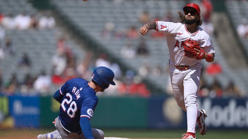 Los Angeles Angels’ Jack López throws from second base as Texas Rangers’ Jonah Heim is out in a double play during the fourth inning of a baseball game Sunday, Sept. 29, 2024, in Anaheim, Calif. (AP Photo/John McCoy)