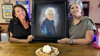 Christi Erpillo and Johnna McKee pose with a portrait of their mother, Wada “Fernie” Winter.