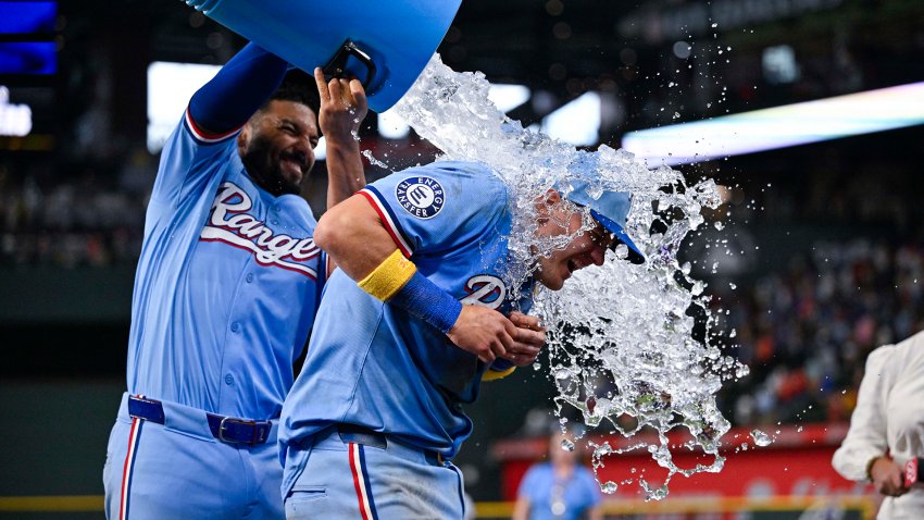 Sep 1, 2024; Arlington, Texas, USA; Texas Rangers third baseman Josh Jung (6) is doused with water by second baseman Marcus Semien (2) after Jung hits a game winning three run walk-off home run during the tenth inning against the Oakland Athletics at Globe Life Field. (Mandatory Credit: Jerome Miron-USA TODAY Sports)