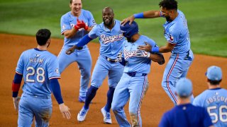 Sep 22, 2024; Arlington, Texas, USA; Texas Rangers right fielder Adolis Garcia (53) and catcher Jonah Heim (28) and second baseman Marcus Semien (2) and left fielder Wyatt Langford (36) and third baseman Ezequiel Duran (20) celebrate after Semien hits a single and drives in the game winning run against the Seattle Mariners during the ninth inning at Globe Life Field. Mandatory Credit: Jerome Miron-Imagn Images