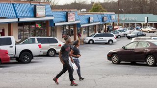 People walk past a strip mall in Clarkston, Georgia.