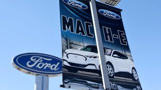 A banner advertises the Ford Mustang Mach-E electric vehicle at a Ford dealership on August 21, 2024 in Glendale, California. 