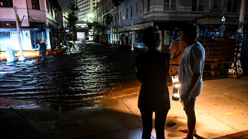 People watch water-flooded streets after Hurricane Milton made landfall in Fort Myers, Florida, on October 9, 2024. Milton made landfall in Florida October 9, 2024 as an “extremely dangerous” Category 3 hurricane, packing life-threatening storm surge, extreme winds and flash flooding, the National Hurricane Center (NHC) said. “Data indicate the eye of Hurricane Milton has made landfall near Siesta Key in Sarasota County along the west coast of Florida,” the NHC said in an 8:30 pm (0030 GMT Thursday) bulletin. (Photo by CHANDAN KHANNA / AFP) (Photo by CHANDAN KHANNA/AFP via Getty Images)