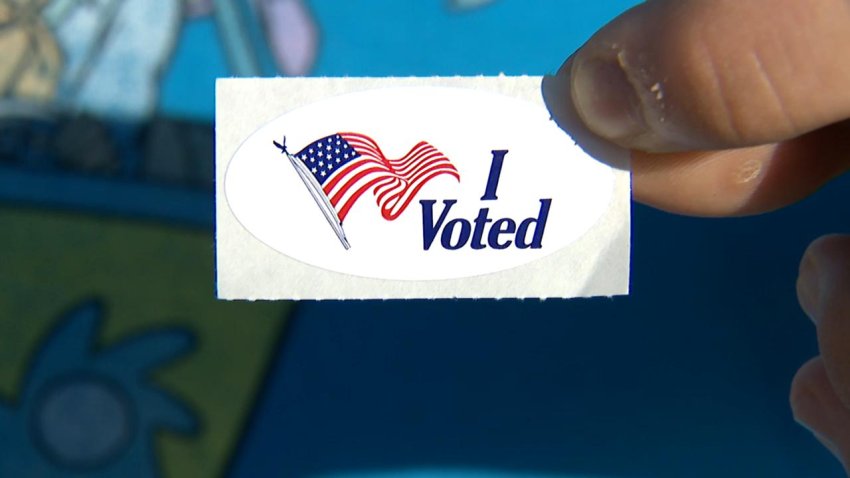 A Tarrant County voter holds up their sticker after casting their ballot. (NBC 5)