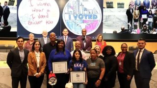 Dallas Samuell High School student Mareily L. , center in the Rangers jersey, won the county’s annual “I voted” sticker design contest.