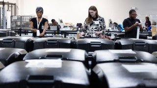 Gwinnett County election workers organize and prepare early in-person voting machines for final vote tabulation at the Gwinnett Voter Registrations and Elections on November 5, 2024 in Lawrenceville, Georgia.