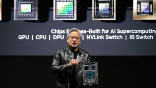 Jensen Huang, co-founder and chief executive officer of Nvidia Corp., holds up the company’s AI accelerator chips for data centers as he speaks during the Nvidia AI Summit Japan in Tokyo, Japan, on Wednesday, Nov. 13, 2024. 