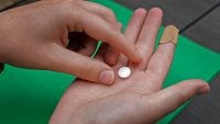 FILE - A patient prepares to take the first of two combination pills,