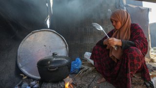 Yasmin Eid cooks at her family's tent i