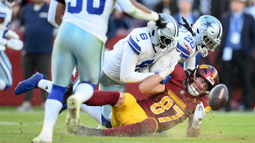 Washington Commanders tight end John Bates (87) fumbles during the second half of an NFL football game against the Dallas Cowboys, Sunday, Nov. 24, 2024, in Landover, Md. (AP Photo/Nick Wass)