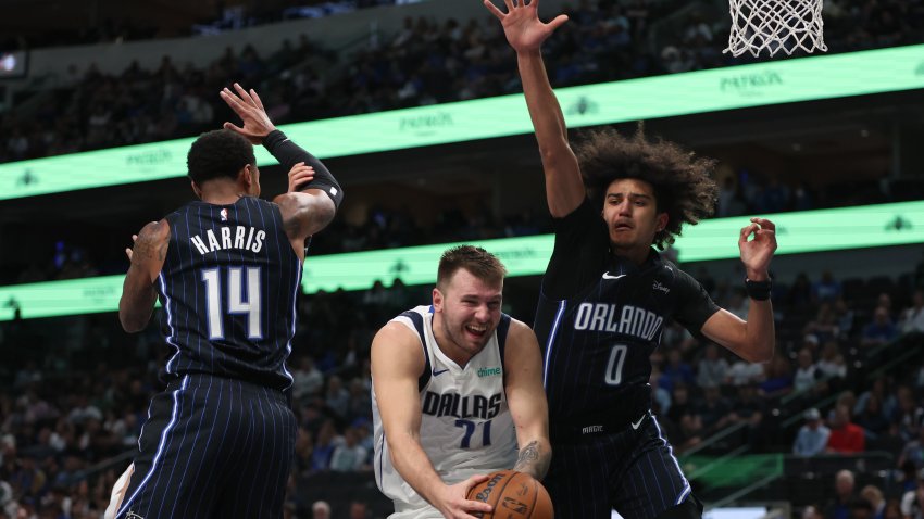 DALLAS, TEXAS – NOVEMBER 03: Luka Doncic #77 of the Dallas Mavericks drives with the ball between Gary Harris #14 and Anthony Black #0 of the Orlando Magic during the second half at American Airlines Center on November 03, 2024 in Dallas, Texas.