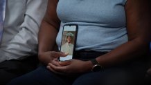 Sheryl Buchanan holds her phone with a photo of her brother, Thurlow, who has been missing since 1987.