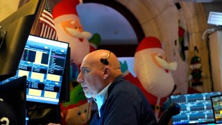 A trader works on the floor of the New York Stock Exchange (NYSE) at the opening bell on November 26, 2024, in New York City.