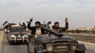 National Syrian Army soldiers celebrate after opposition forces led by Hayat Tahrir al-Sham took control of the Hama city center and surrounding villages on Dec. 6, 2024, in Hama, Syria.