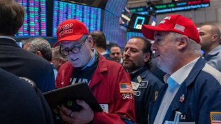 Traders watch as President-elect Donald Trump walks onto the floor of the New York Stock Exchange with his wife, Melania, after being named Time’s “Person of the Year” for the second time, on Dec. 12, 2024.