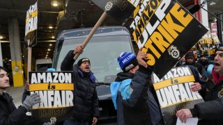 Amazon workers and supporters block a vehicle during a strike organised by the Teamsters union at the Amazon facility in the Queens borough of New York City, U.S. December 20, 2024.