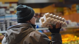 A customer, holding a carton of eggs at a supermarket, in United States on Dec. 20, 2024. 