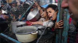 FILE - Palestinians line up to receive free meals at Jabaliya refugee camp in the Gaza Strip on March 18, 2024.