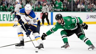 St. Louis Blues center Dylan Holloway (81) attempts to get past Dallas Stars left wing Jamie Benn (14) with control of the puck in the second period of an NHL hockey game in Dallas, Saturday, Dec. 14, 2024. (AP Photo/Tony Gutierrez)