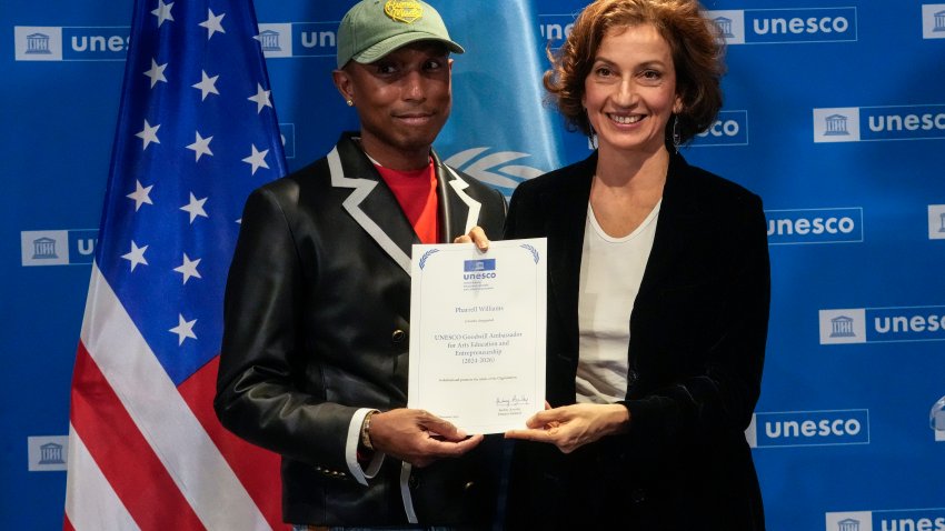 Pharrell Williams, left, holds his diploma of Goodwill Ambassador for for Arts, Education and Entrepreneurship as he poses with UNESCO Director General Audrey Azoulay at UNESCO headquarters in Paris, Tuesday, Dec. 17, 2024.