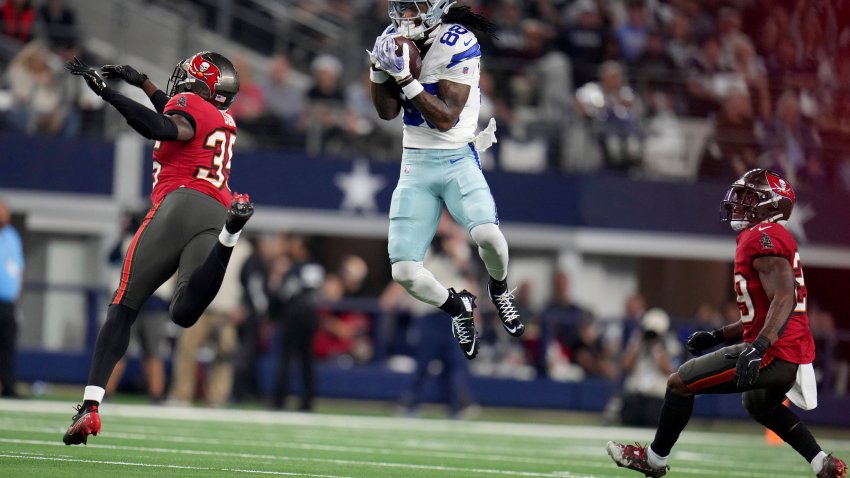 Dallas Cowboys wide receiver CeeDee Lamb (88) catches a pass between Tampa Bay Buccaneers cornerback Jamel Dean (35) and Christian Izien (29) in the first half of an NFL football game in Arlington, Texas, Sunday, Dec. 22, 2024. (AP Photo/Julio Cortez)