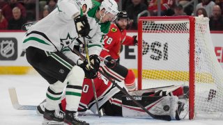 Chicago Blackhawks goaltender Arvid Soderblom makes a save on Dallas Stars right wing Evgenii Dadonov, center, as left wing Jamie Benn (14) skates in to score a goal during the first period of an NHL hockey game Sunday, Dec. 29, 2024, in Chicago. (AP Photo/Erin Hooley)