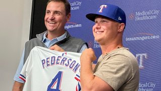 Texas Rangers president of baseball operations Chris Young, left, poses for photos with Joc Pederson during a news conference announcing Pederson’s two-year contract with the team, Monday, Dec. 30, 2024, in Arlington, Texas.