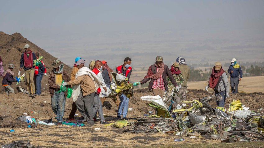 FILE – Debris is carried at the scene of an Ethiopian Airlines flight crash near Bishoftu, or Debre Zeit, south of Addis Ababa, Ethiopia, on March 11, 2019. A spokesman says Ethiopian Airlines has grounded all its Boeing 737 Max 8 aircraft as a safety precaution, following the crash of one of its planes in which 157 people were killed. (AP Photo/Mulugeta Ayene)