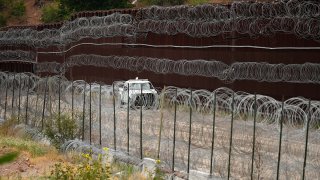 FILE - A vehicle drives along the U.S. side of the U.S.-Mexico border wall in Nogales, Ariz., on June 25, 2024.