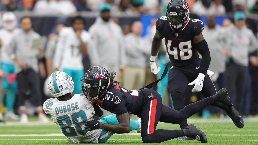 HOUSTON, TEXAS – DECEMBER 15: Grant DuBose #88 of the Miami Dolphins is hit by Calen Bullock #21 of the Houston Texans during the third quarter at NRG Stadium on December 15, 2024 in Houston, Texas. (Photo by Alex Slitz/Getty Images)