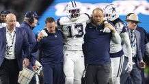 Dec 9, 2024; Arlington, Texas, USA; Dallas Cowboys linebacker DeMarvion Overshown (13) is helped off the field after an injury in the second half against the Cincinnati Bengals at AT&T Stadium.