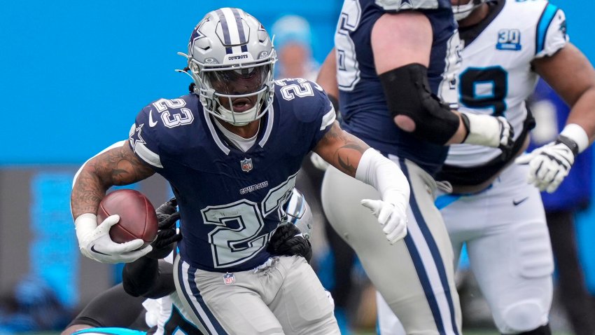 Dec 15, 2024; Charlotte, North Carolina, USA; Dallas Cowboys running back Rico Dowdle (23) runs out of a tackle by Carolina Panthers linebacker Claudin Cherelus (53) during the first quarter at Bank of America Stadium.