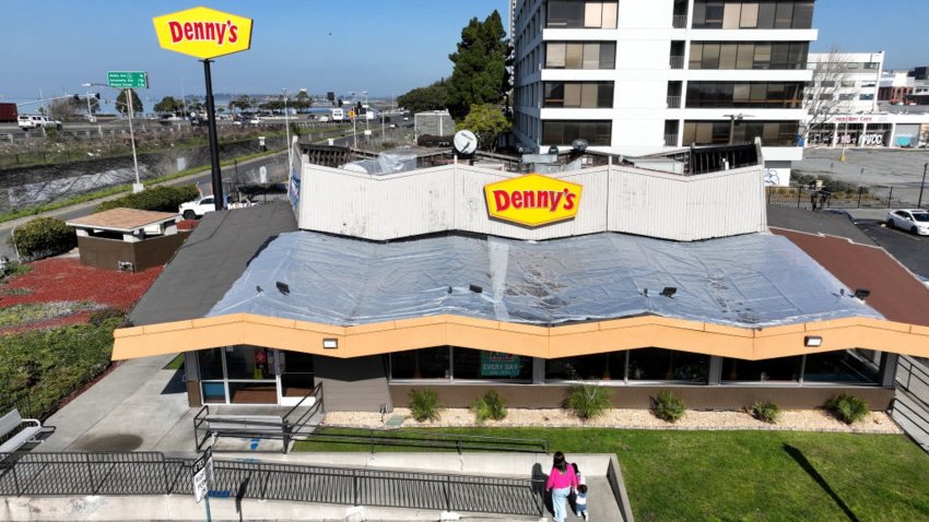 In an aerial view, customers enter a Denny’s restaurant on February 13, 2023 in Emeryville, California. 